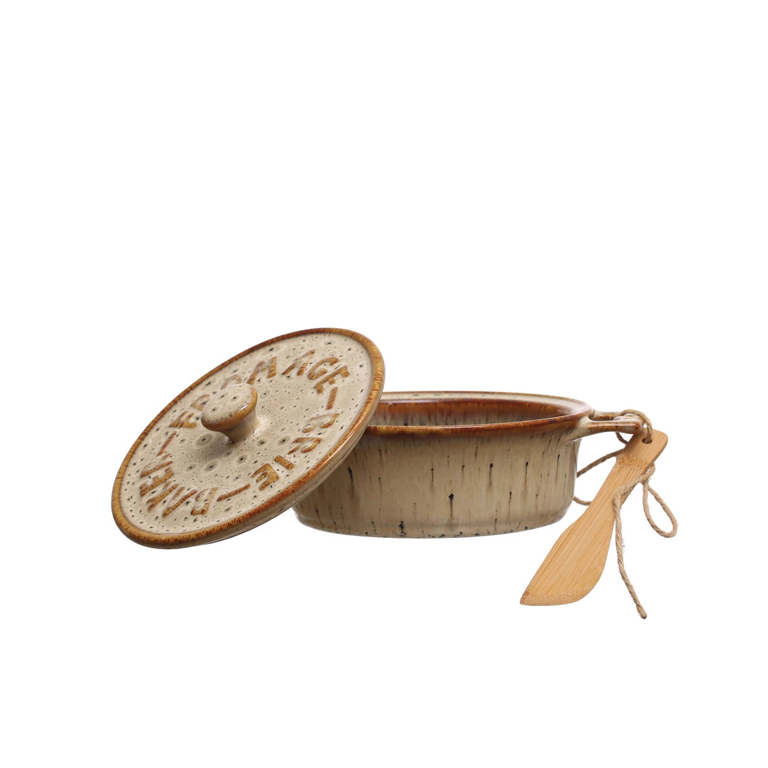 A rustic Brie Baker by Creative Co-op, topped with a speckled beige lid labeled “Brie Baker,” is shown partially open to reveal the inside and comes with a bamboo spreader inspired by farmhouse knives, tied neatly with string.