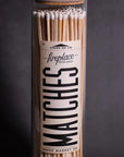 A close-up of a tall glass jar filled with long Fireplaces Apothecary Matches from Faire. The bold label details are visible, and the background is dark and plain.