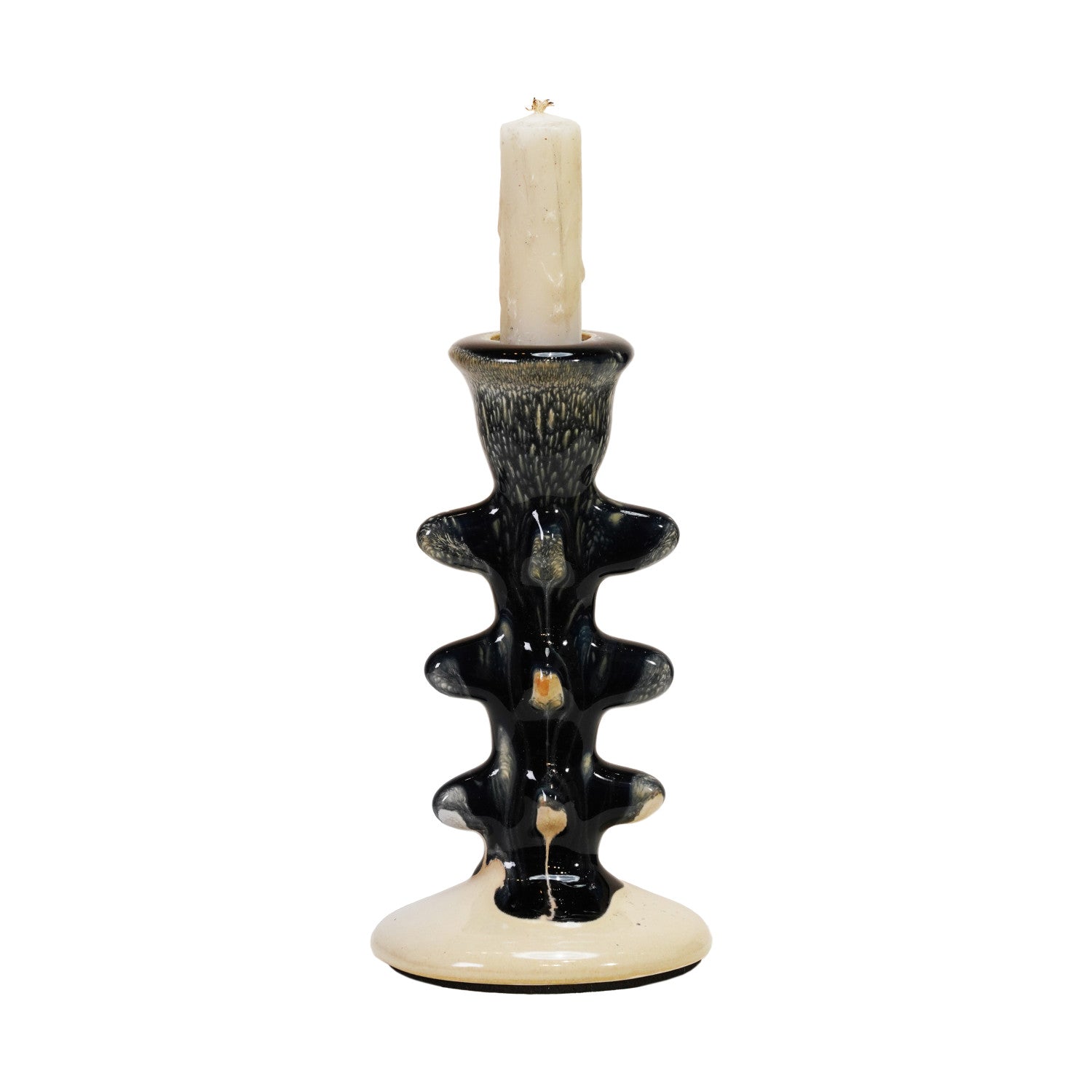 The Creative Co-op Terra-Cotta Taper Holder features a black and cream abstract wavy design, glossy finish, and holds a white candle. This sculptural piece adds modern flair to any room.