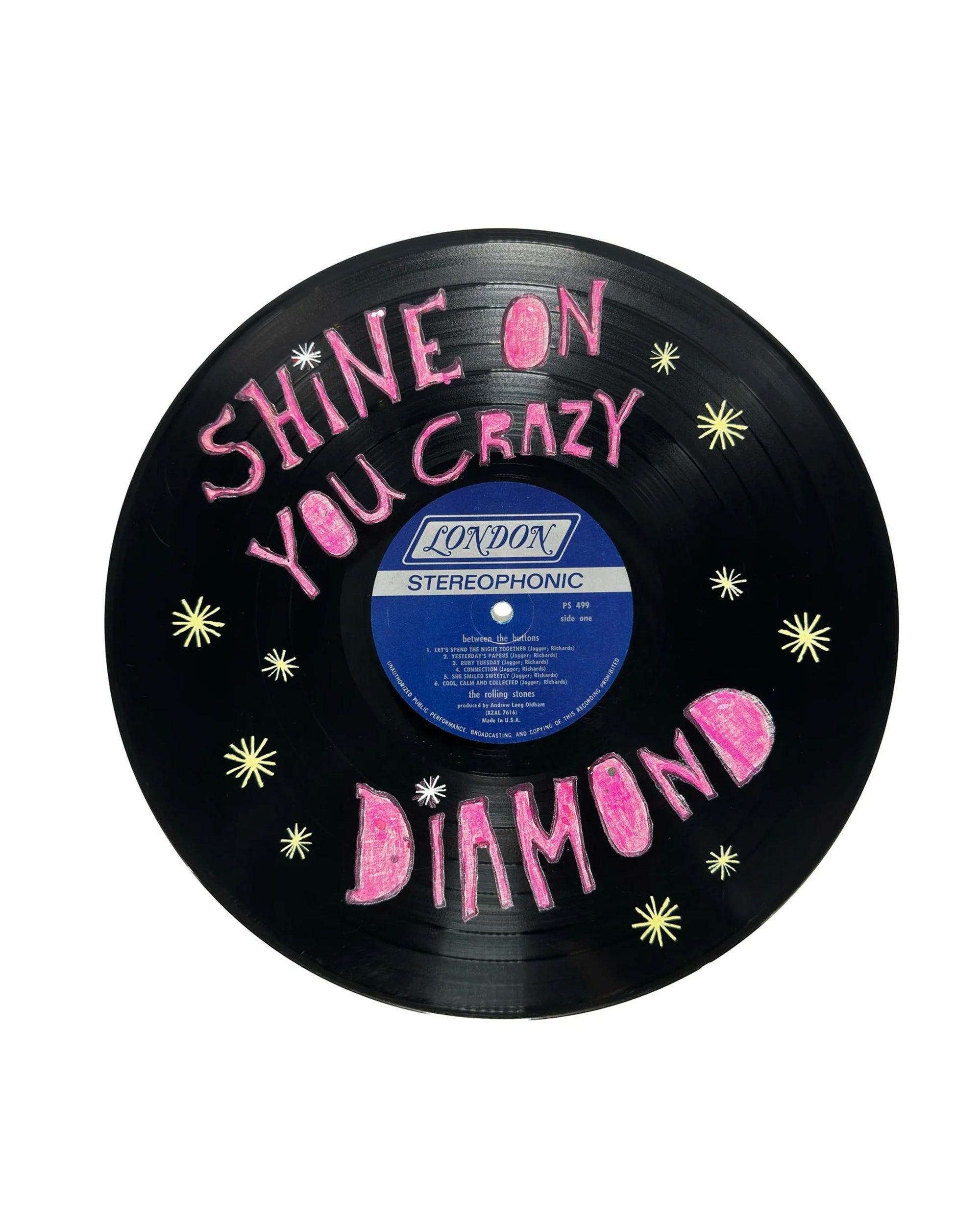 The Shine On Your Crazy Diamond Vinyl Record by Sugarboo Designs is a black hanging art piece featuring a blue label, pink hand-drawn lettering, and yellow stars—a unique wall decoration inspired by Sugarboo’s signature style.