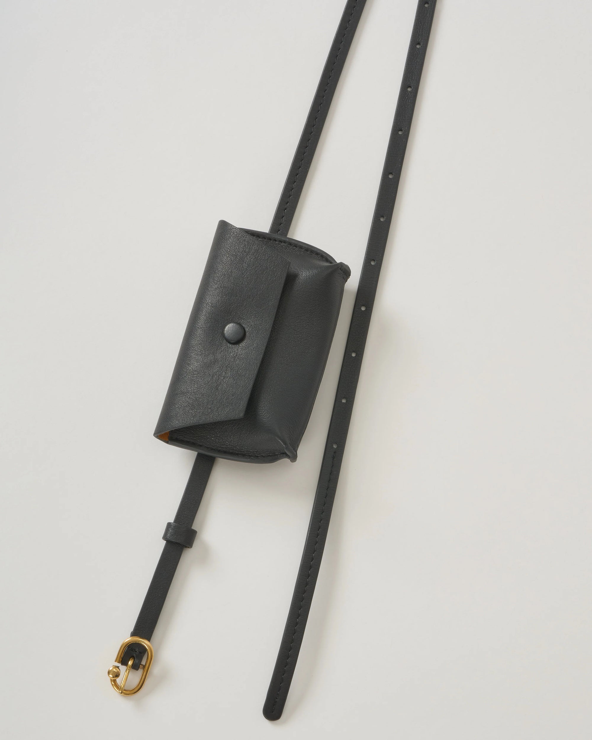 Black calfskin double wrap belt with gold hardware and pouch by Rachel Comey, shown flat.
