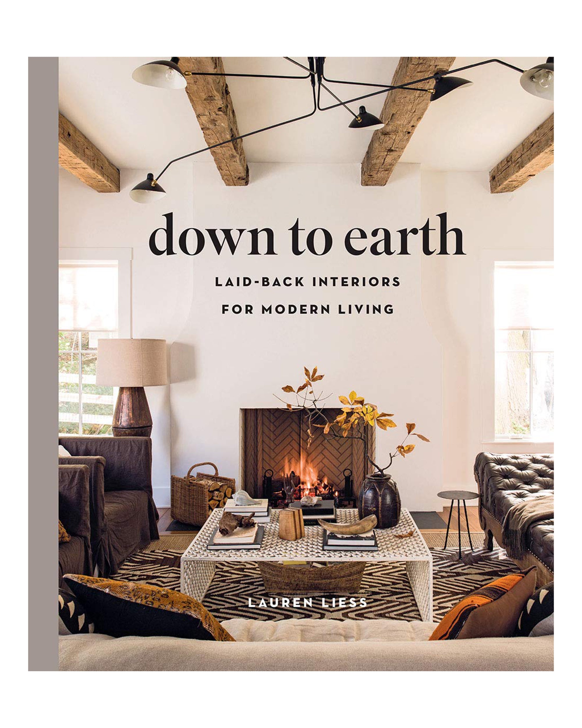 Cover of "Down to Earth" by Hachette Book Group showcases a cozy living room with exposed wood beams, fireplace, and rustic decor—an inviting blend of modern style and comfort.