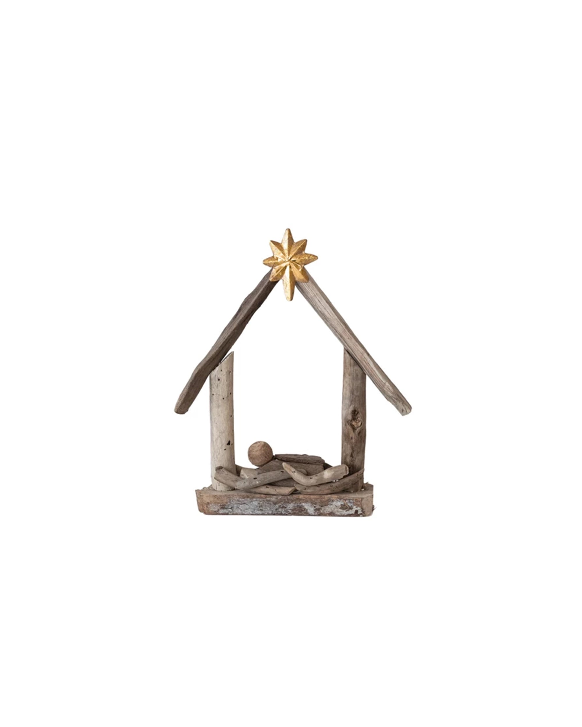 The Creative Co-op Driftwood Manger is a simple nativity decoration crafted from acacia wood, featuring a stable with a gold star and a handmade baby Jesus figure in the center.