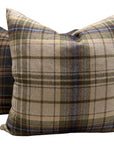 The Durrell Pillow 24X24 by TL At Home features a square shape with a beige, blue, and olive green wool plaid pattern on textured fabric. A second similar pillow is partially seen in the background.