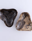 Heart stones beside a Mexican onyx chocolate triangular bowl with swirling patterns from Bungalow Furniture & Accessories.