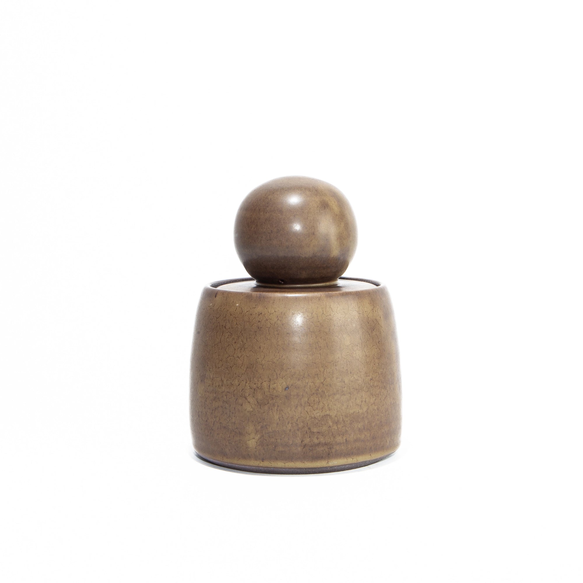 The Faire Olive Brown Stash Jar is a small, hand-thrown stoneware jar with a rounded base and spherical lid, finished in a subtle satin glaze and shown against a plain white background.