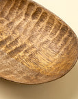 Mango wood Terrain Carved Dish S by Faire with striped grain, shown on a beige background.