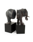 The Zentique Elephant Bookends feature an elephant split in half, with each section on a black rectangular base, facing each other to create a unique and decorative touch for any bookshelf.