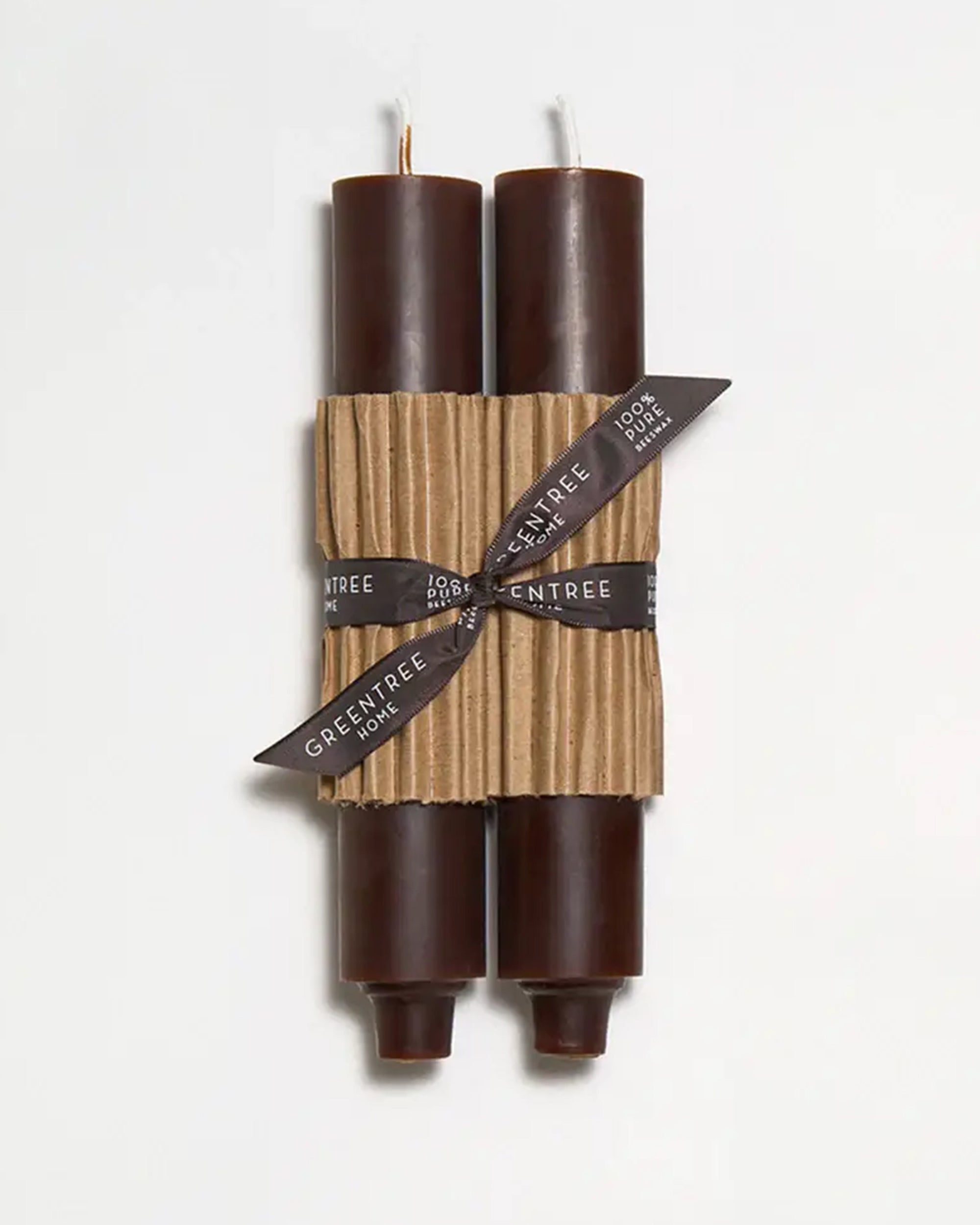 Two dark brown Faire 9" Taper Candles in Espresso are hand-poured, bundled with a corrugated cardboard sleeve, and tied with a black ribbon labeled "GREENTREE HOME 100% PURE," shown on a plain white background.