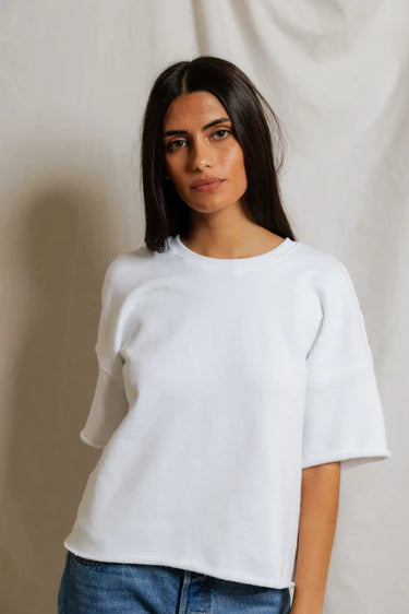 A woman with long dark hair models the Perfectwhitetee French Terry SS Loose Sweatshirt and blue jeans against a neutral backdrop, looking at the camera with a relaxed expression that highlights the sweatshirt’s loose fit.