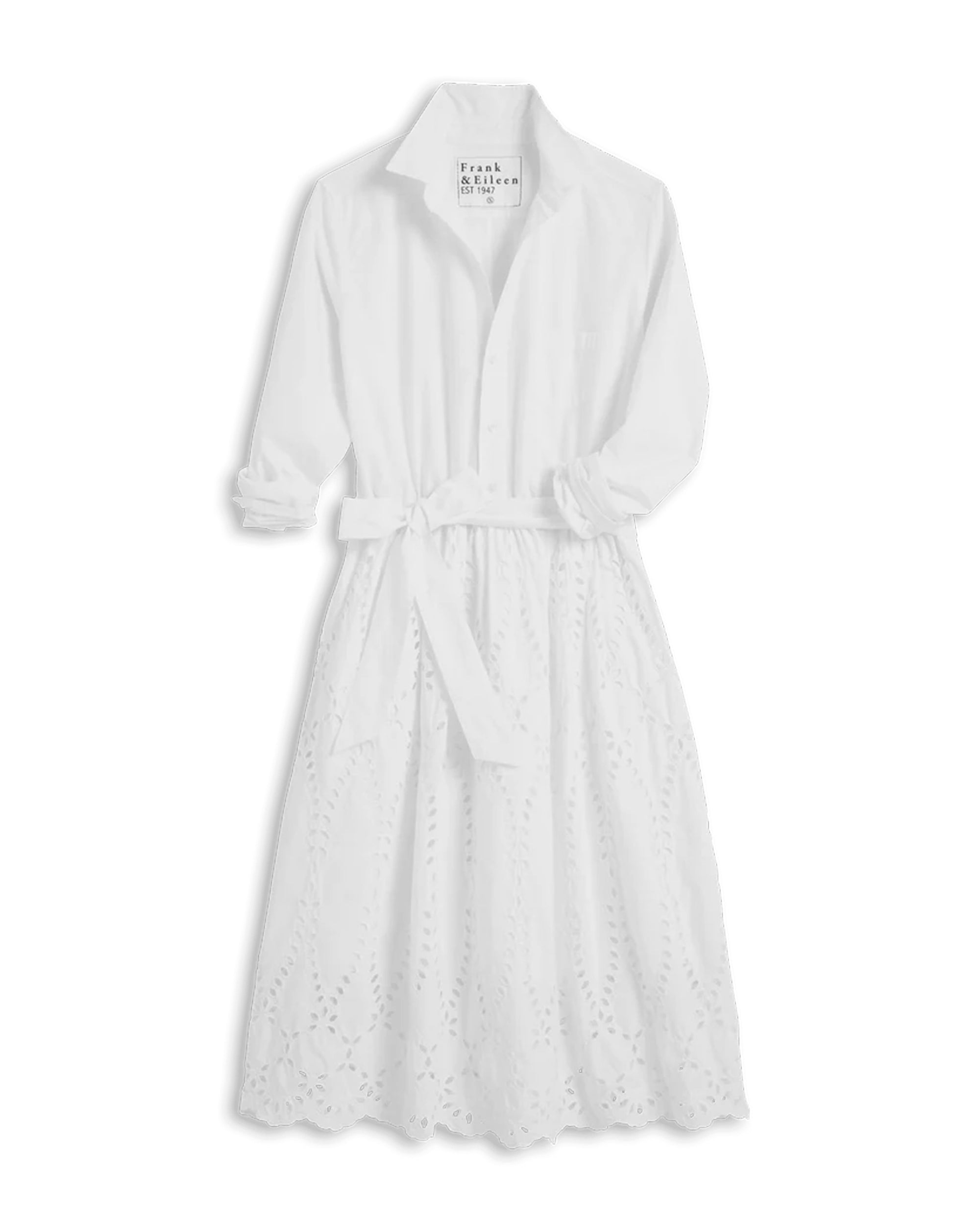 The Gracie Midi Eyelet Dress by Frank & Eileen is a crisp white collared shirt dress with rolled-up long sleeves, a tie waist, and an eyelet lace skirt. This feminine midi dress offers a classic, flattering silhouette.