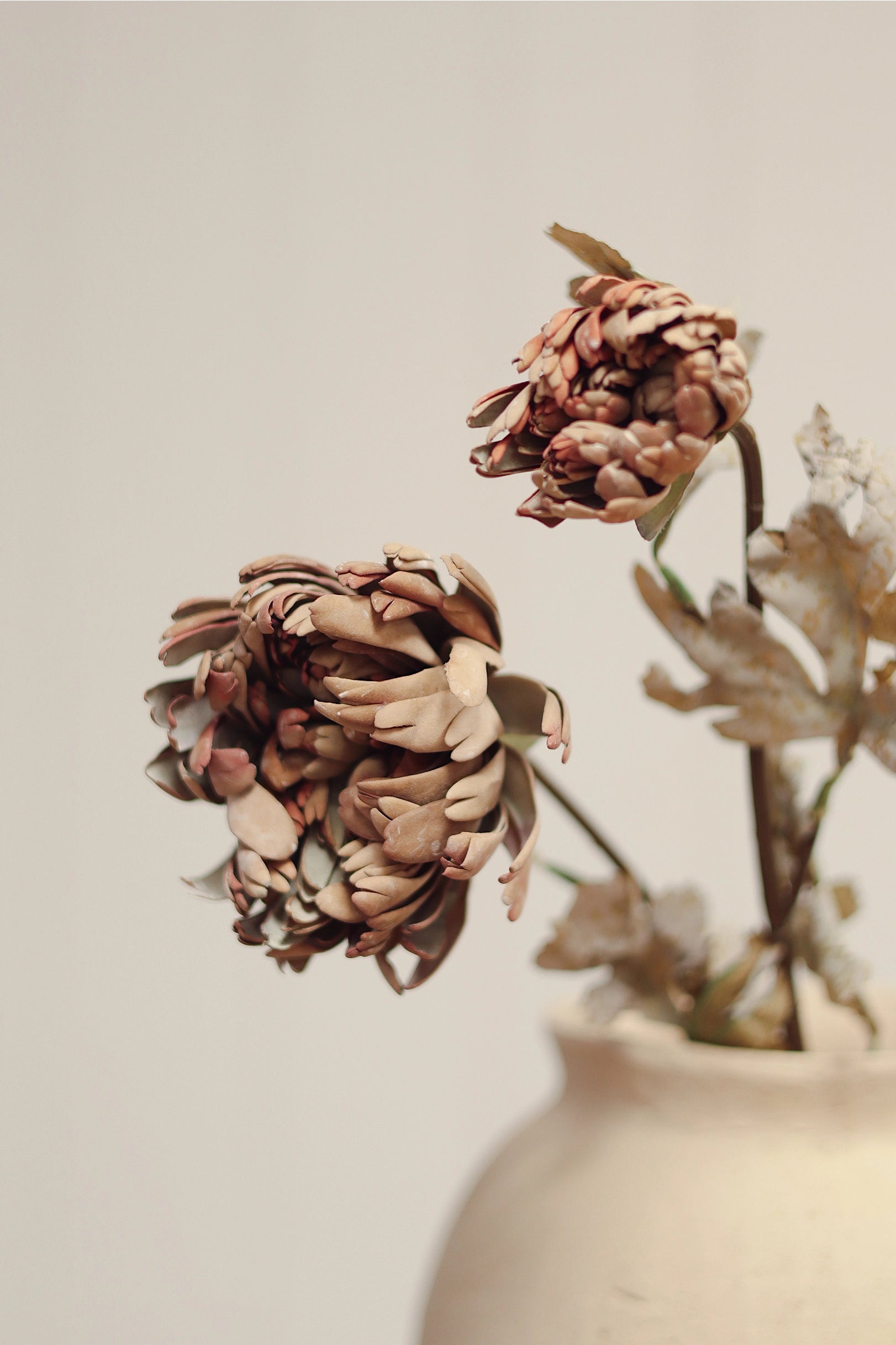 Brown dahlia spray by Faire displayed in a vase, minimal style, neutral background.