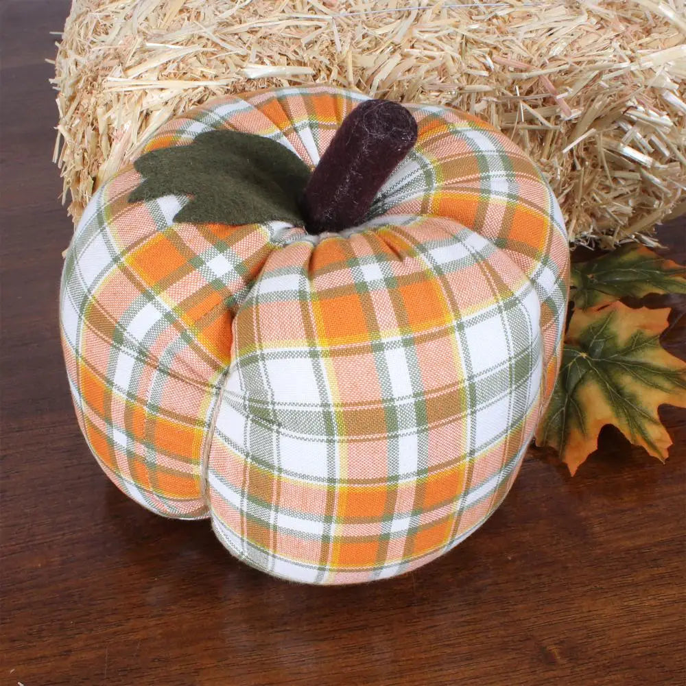 The Faire Pumpkin features an orange, white, and green plaid fabric with a felt leaf, dark brown stem, and autumn leaves—making it the perfect farmhouse decor accent for fall.