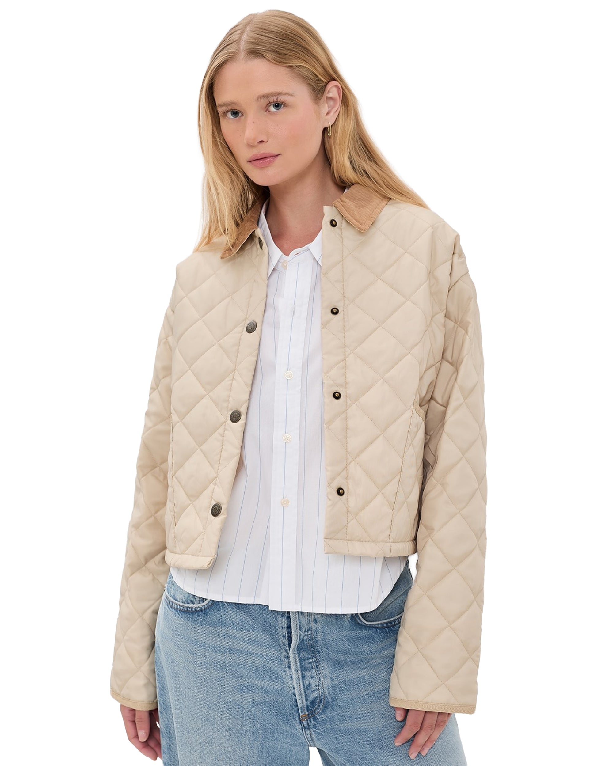 A woman faces the camera with a neutral expression, wearing the Denimist FAULKNER QUILTED JACKET in light beige over a white button-up shirt and blue jeans, set against a plain background.