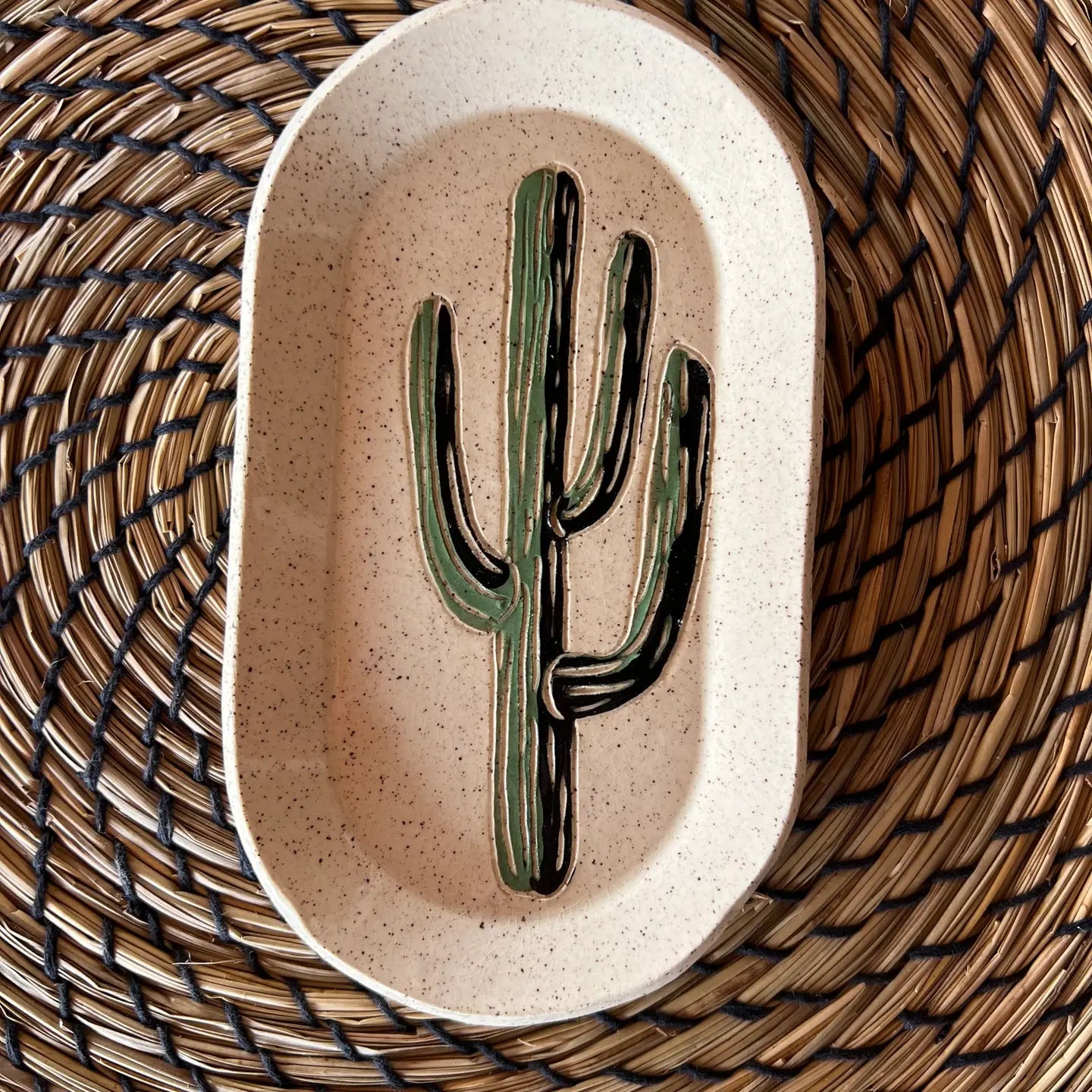 The Faire Saguaro Oval Trinket Dish features a hand-painted green cactus at its center, offering desert-inspired charm—ideal for organizing jewelry or keys and adding a stylish accent to your space.