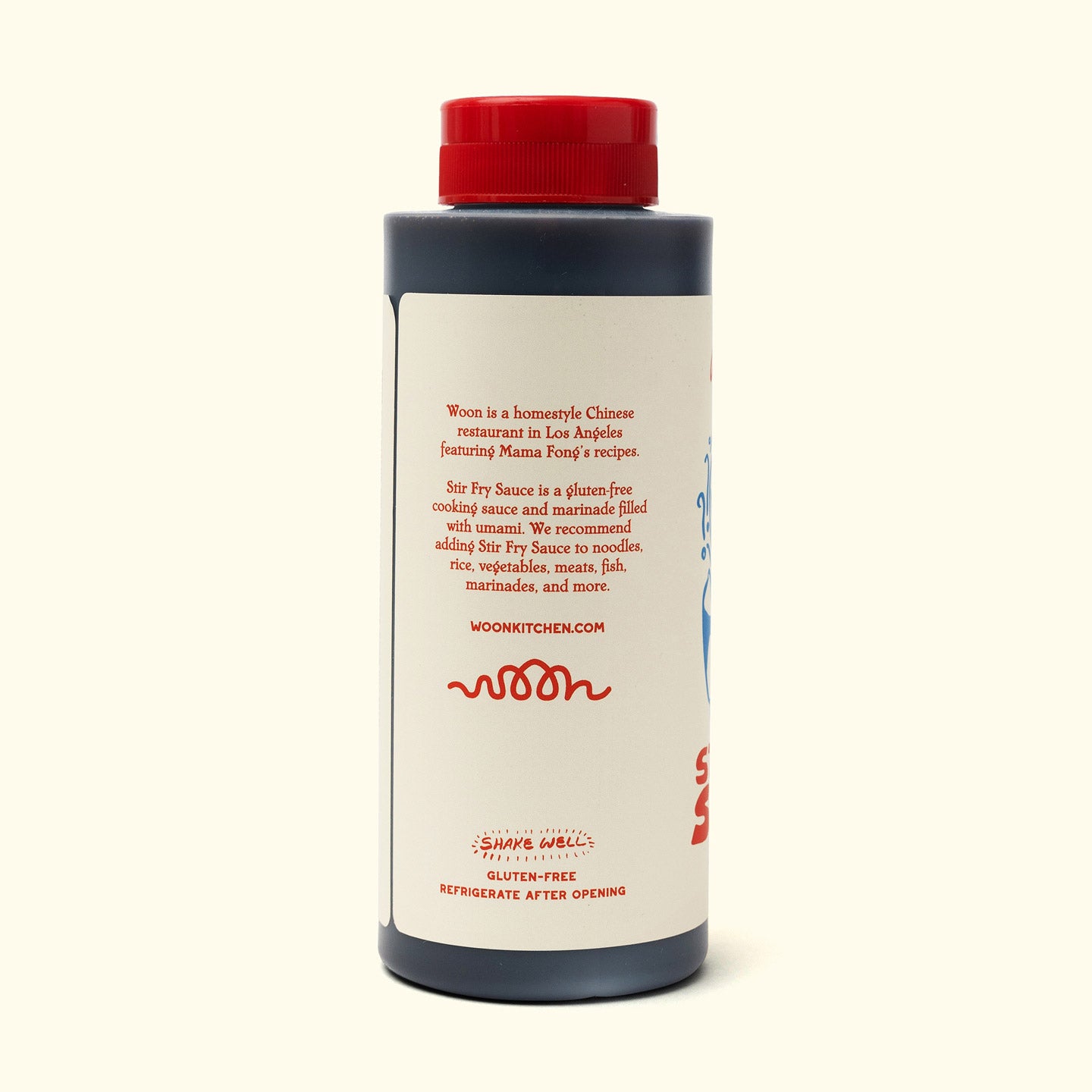 A plastic bottle with a red cap contains Faire’s Woon Stir Fry Sauce, a gluten-free cooking sauce. The label gives usage tips, shaking and refrigeration advice, website info, and is ideal for stir-fries or marinades.