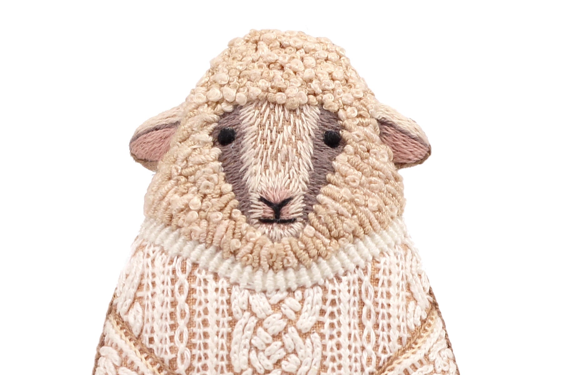 The Faire Sheep Embroidery Kit features a detailed sheep design with textured beige and cream wool, black eyes, and a simple expression on white—ideal for DIY embroidery enthusiasts or embroidered doll kit collections.