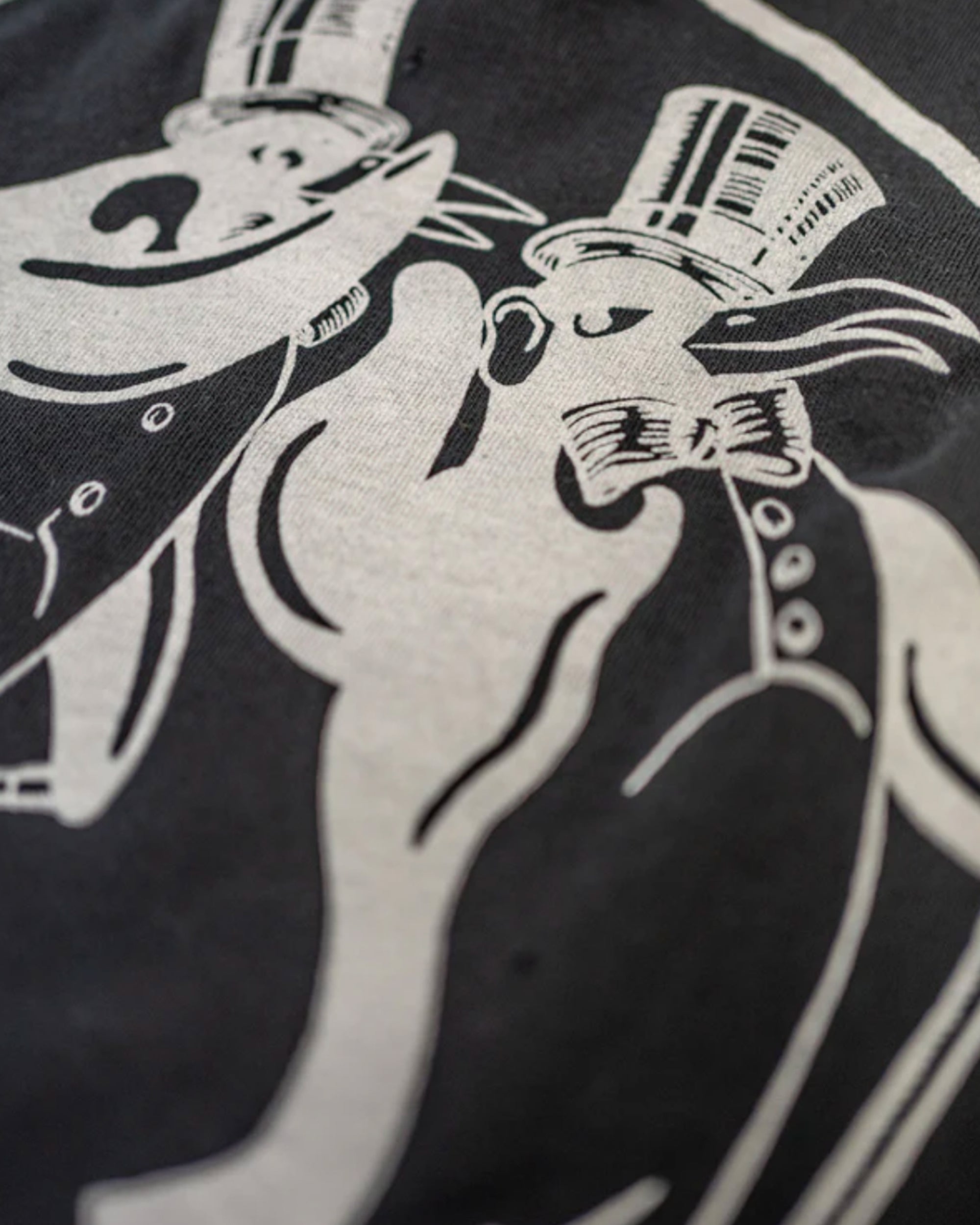 The Fleetwood Mac Tee by Made Worn features a black and white illustration of a bear and rabbit in top hats and tuxedos, dancing joyfully. This vintage unisex tee is made in the USA from 100% cotton for comfort and timeless appeal.