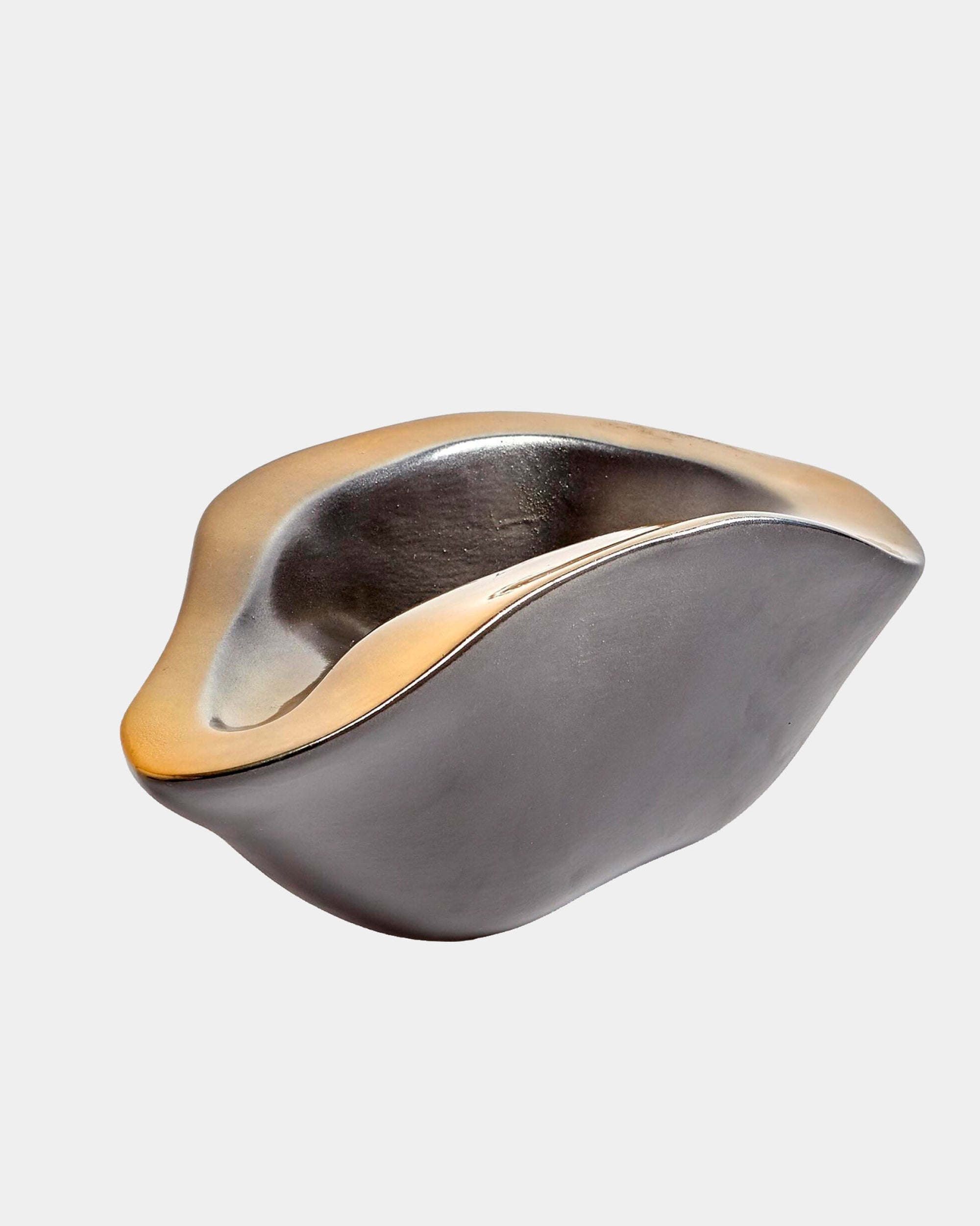 The Formation bowl by Global Views is a modern Italian ceramic piece with smooth curves, an organic shape, a matte black exterior, and a gold-toned rim, displayed against a plain white background.
