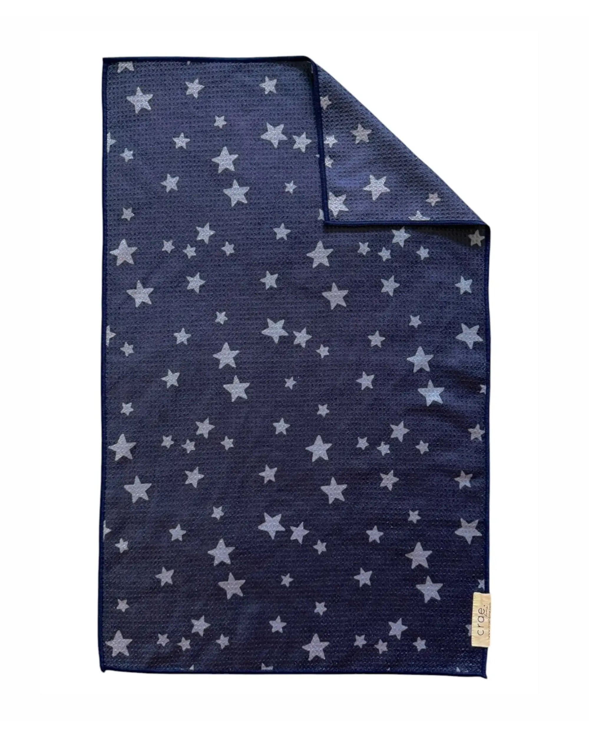 The Faire "Hand Towel: Franklin" is a dark blue, rectangular waffle weave microfiber towel with white stars, a small beige corner label, and a folded edge to highlight its high-absorbent, eco-friendly design.