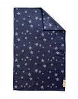 The Faire "Hand Towel: Franklin" is a dark blue, rectangular waffle weave microfiber towel with white stars, a small beige corner label, and a folded edge to highlight its high-absorbent, eco-friendly design.