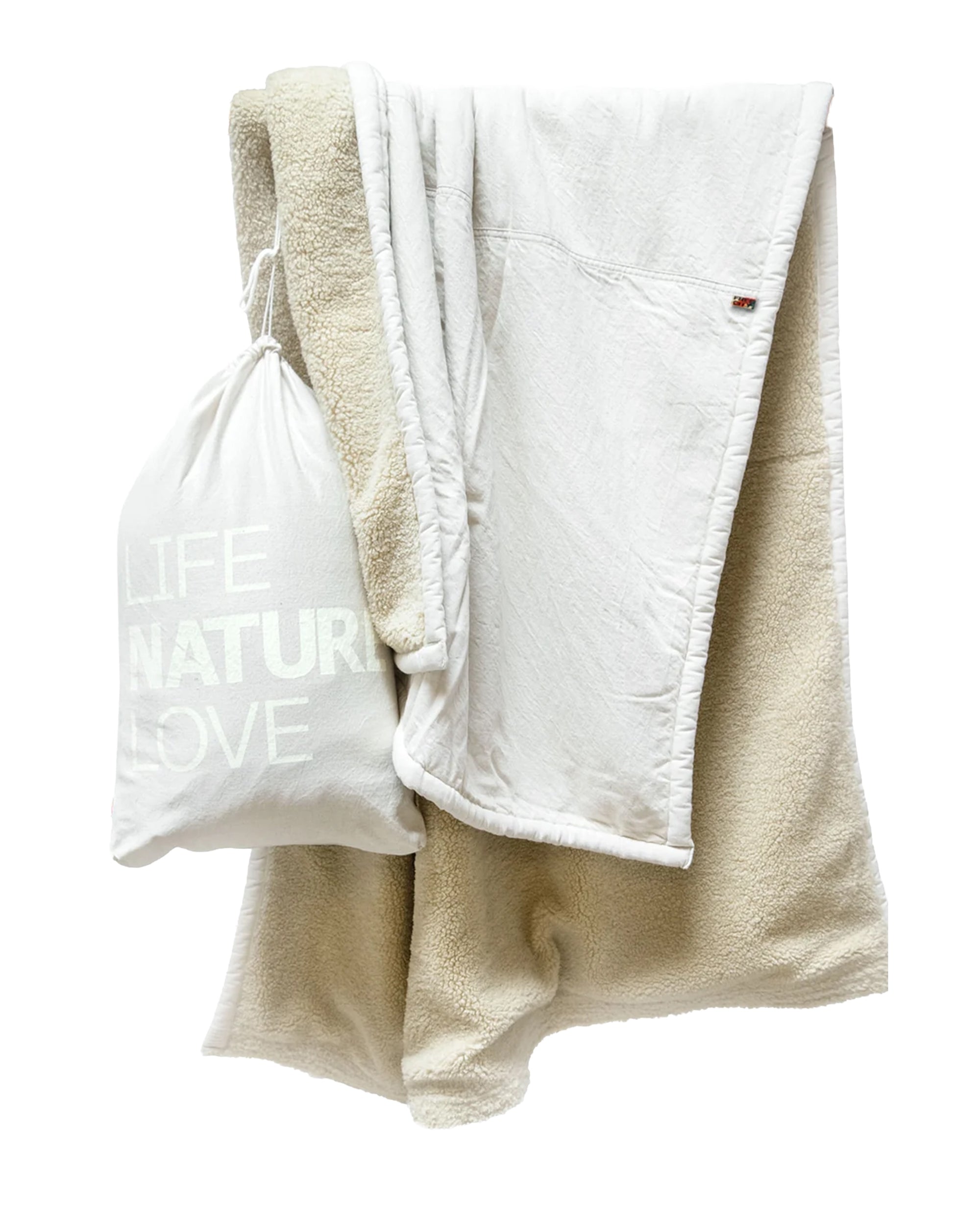 Polar Sherpa Bear Blanket by Free City displayed beside a white LIFE NATURE LOVE bag in a cozy, modern setting.