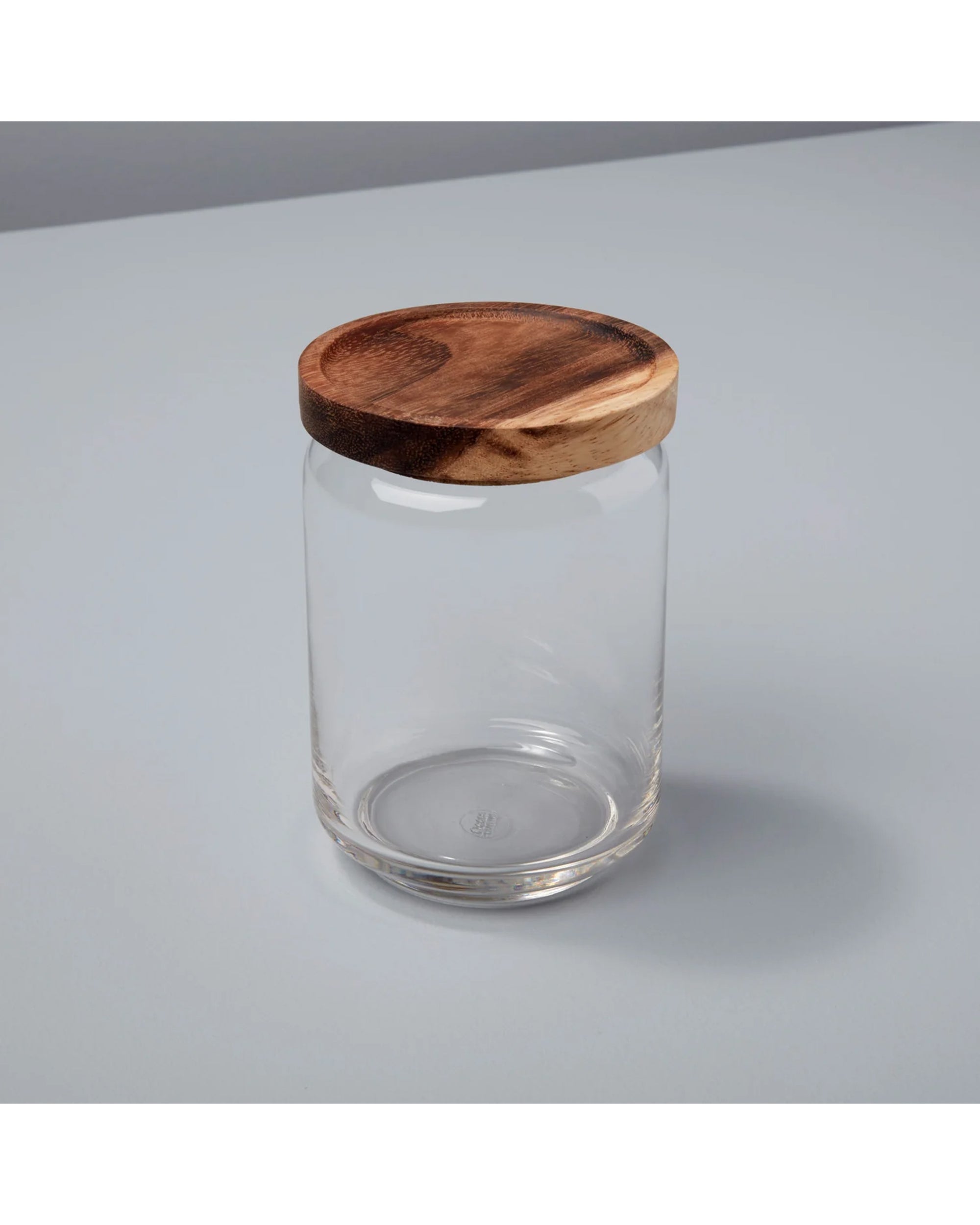The Be Home Glass & Acacia Canister M features a clear glass jar with a round acacia lid, ideal for sustainable kitchen storage and organizing your pantry essentials.
