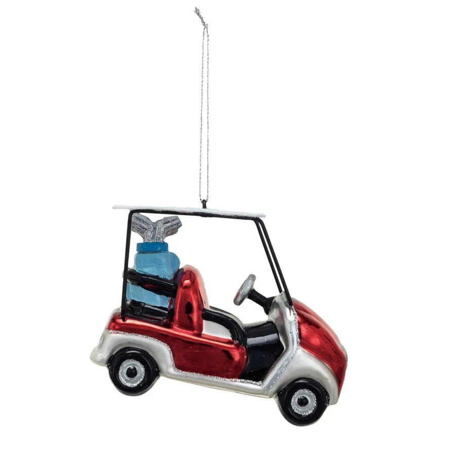 The Creative Co-op Glass Golf Cart Ornament features a red and white cart with a blue glitter golf bag, hanging by a silver string—ideal as a festive golf decoration or gift for any fan.