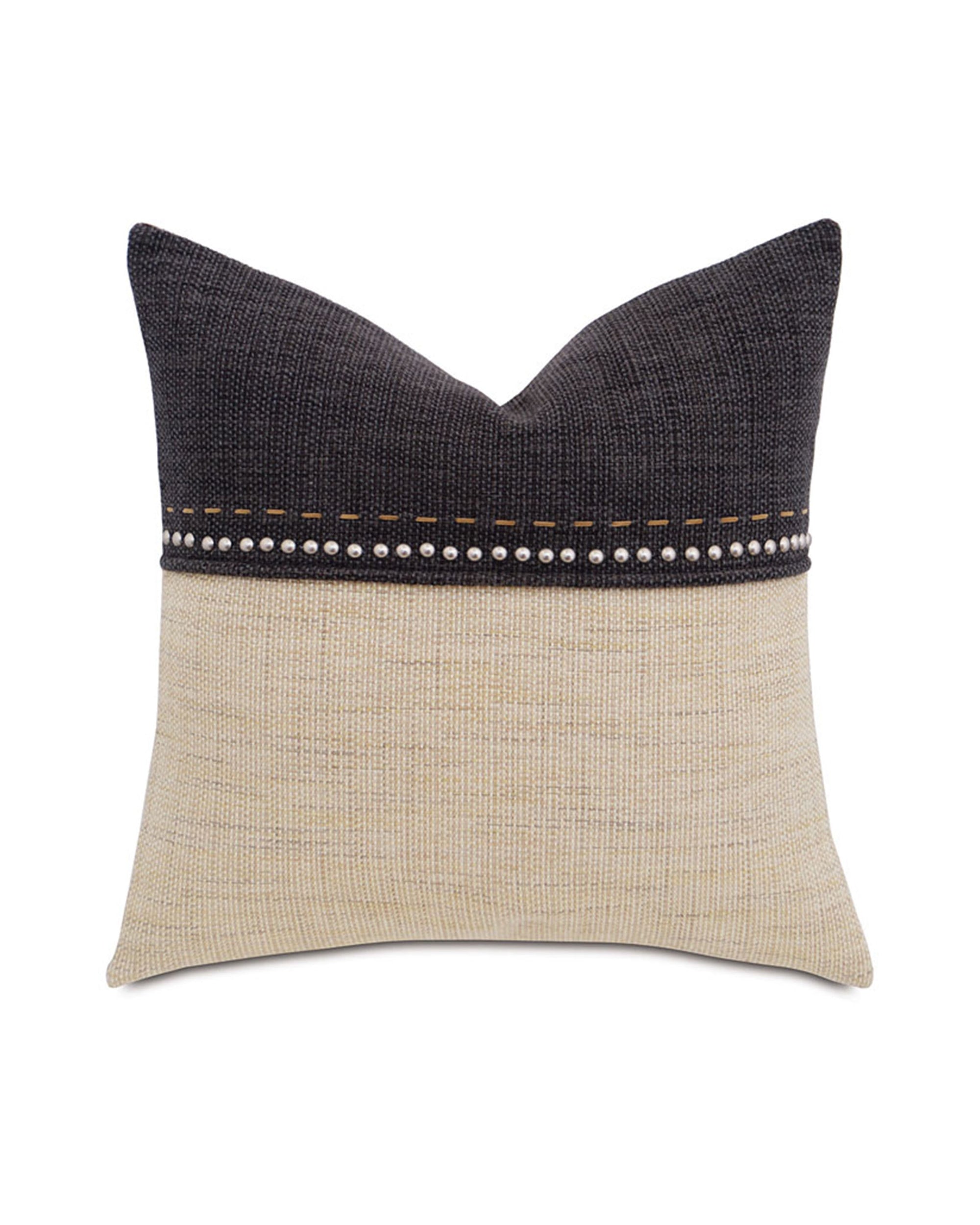 The GILMER BRULEE pillow by Eastern Accents features a dark gray top, beige bottom, and dramatic nailhead accents with tan hand-stitching dividing the textured halves.