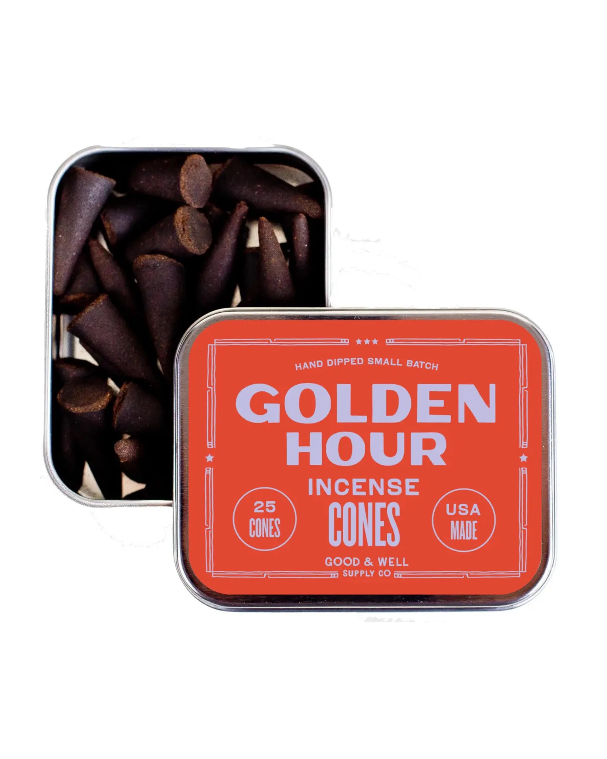 An open tin of Golden Hour Incense by Faire reveals dark brown, hand-dipped cones. The orange lid says “GOLDEN HOUR INCENSE CONES,” “25 CONES,” “USA MADE,” and “FAIRE.”.