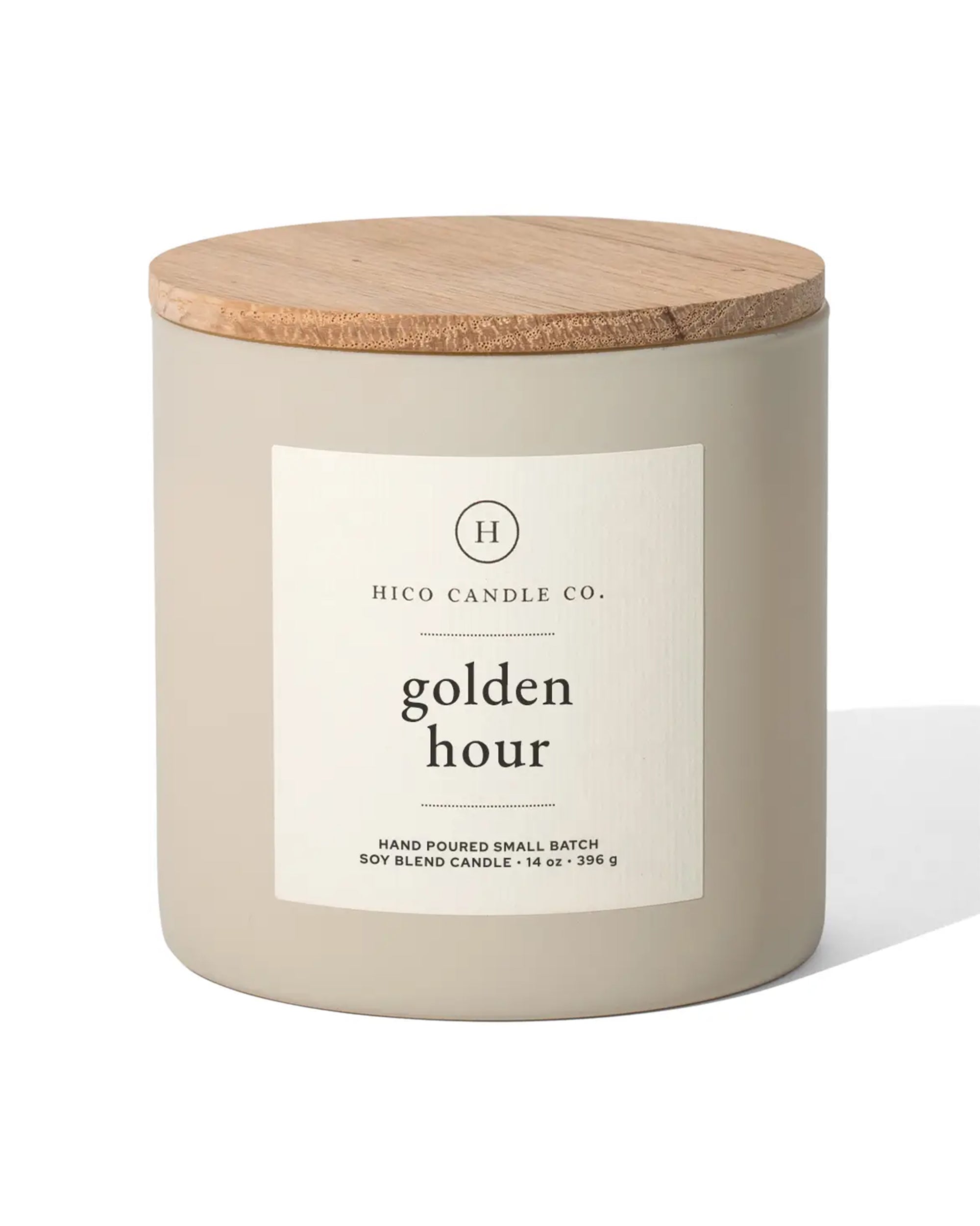 The beige 14oz Golden Hour candle by Faire features a wooden lid, a white label, and is made from a hand-poured soy wax blend infused with passion fruit fragrance.