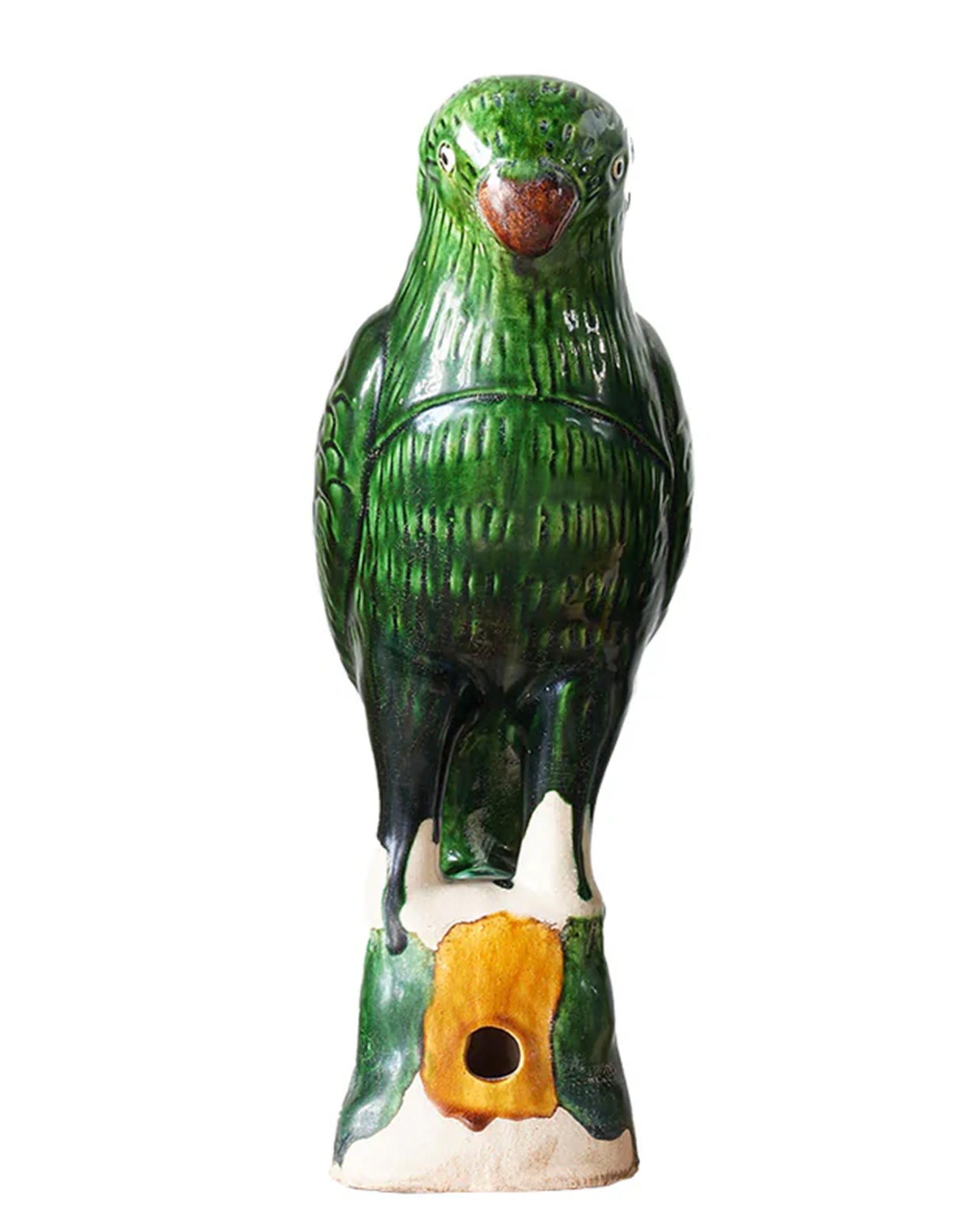 The Blue Ocean Traders Parrot Small is a ceramic sculpture inspired by Jingdezhen hand-painted porcelain, featuring a green parrot on a tree stump with a small hole at the base, set against a white background.