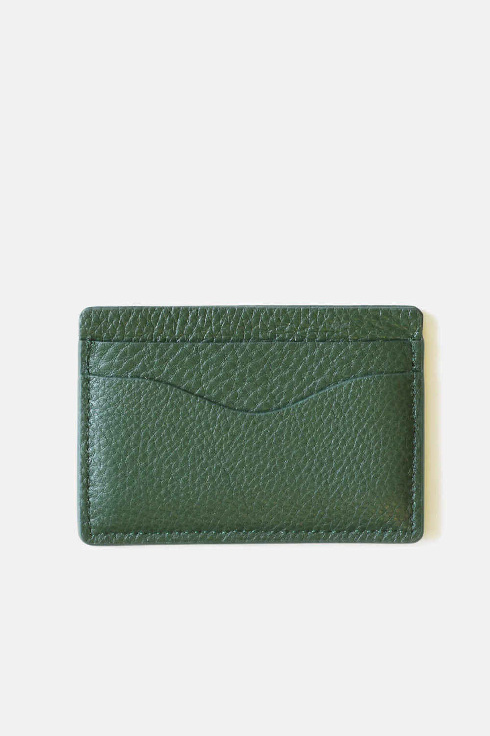 The MENS Leather Cardholder by Curated Basics is crafted from green pebble grain leather, providing a textured surface. It features two card slots on the front and maintains a clean, simple design. The white background accentuates the rich color and intricate texture of this elegant piece.