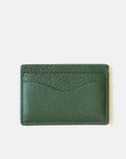 The MENS Leather Cardholder by Curated Basics is crafted from green pebble grain leather, providing a textured surface. It features two card slots on the front and maintains a clean, simple design. The white background accentuates the rich color and intricate texture of this elegant piece.