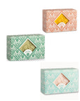 Three Hand and Body Soap Bars by Faire come in patterned orange, green, or pink/green boxes with windows, labeled "Orange & Ginger," "Olive," and "Rose," revealing the artisanal soap inside.
