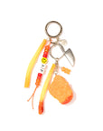The Venessa Arizaga Bag Key Leash features a silver ring, small knife charm, two French fry and one chicken nugget food charms, orange beads, and a beaded strand with “AF” and a smiley—perfect as a playful bag accessory.