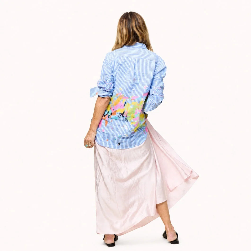 Mia Happimess Studio Shirt by Kerri Rosenthal in a lively pattern, styled with a light pink skirt, shown from the back.