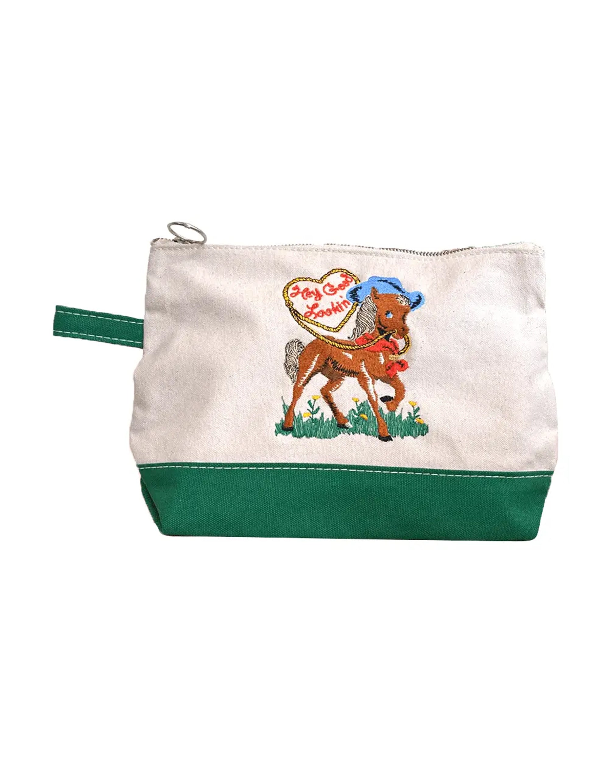 The "Hey Good Lookin'" pouch by Faire features a cartoon horse in a blue hat, green bottom, loop handle, and heart-shaped "Jolly Good" patch—a playful makeup bag for your daily essentials.