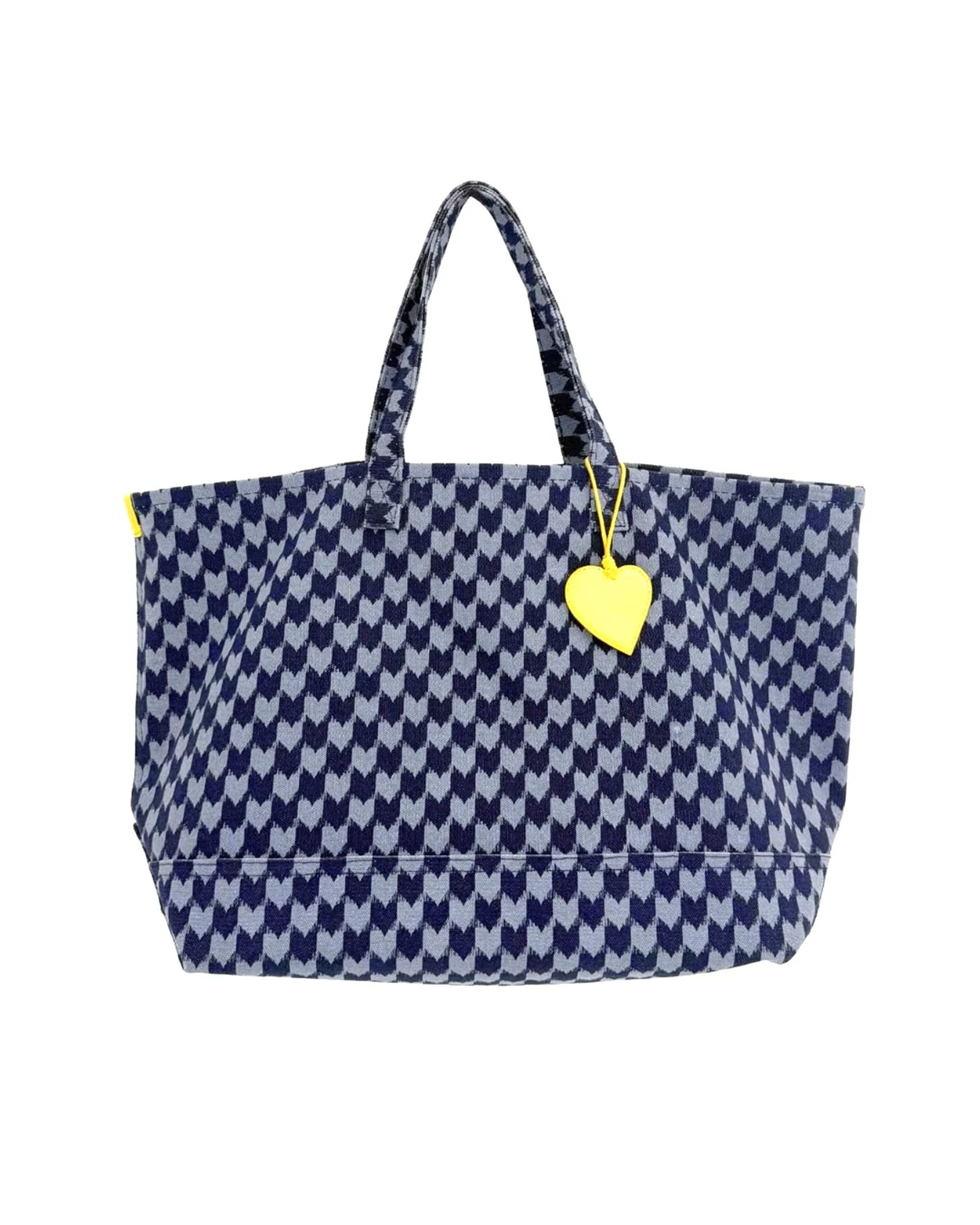 The KR Heart in Check Tote by Kerri Rosenthal features a blue and white houndstooth cotton canvas, two handles, and a yellow heart keychain—perfect for stylishly carrying your daily essentials.