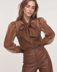 LS French Bow Shirt with puffed sleeves and brown leather high-waisted pants by THE SHIRT, styled for a modern look.