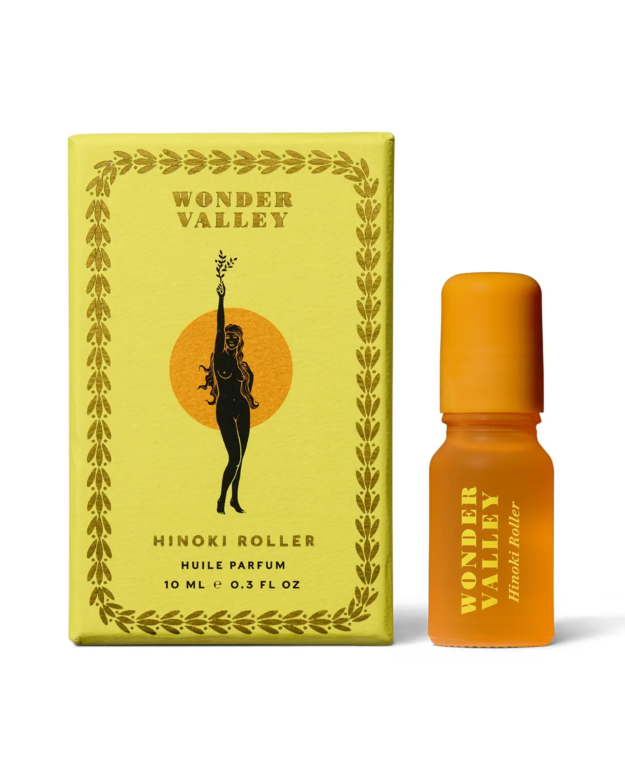 A yellow Faire Hinoki Roll On box with an illustration of a woman holding a branch sits next to a small orange bottle labeled "Faire Hinoki Roll On," featuring a plant-based fragrance with hinoki cedar scent.