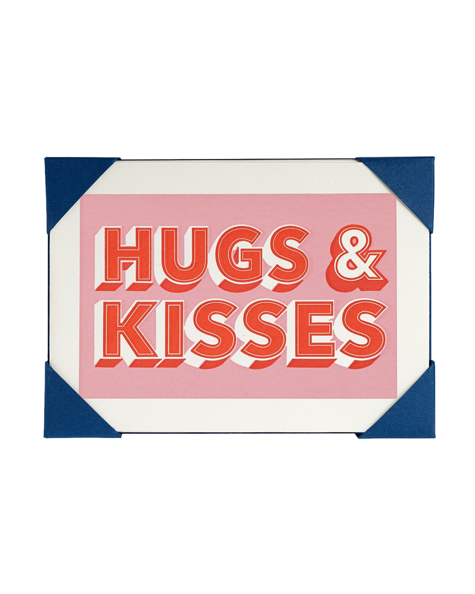 The AG Notelet Card 5pk by Faire features bold red "HUGS & KISSES" on a pink background, held with blue photo corners—a charming choice for sending sweet messages to someone special.