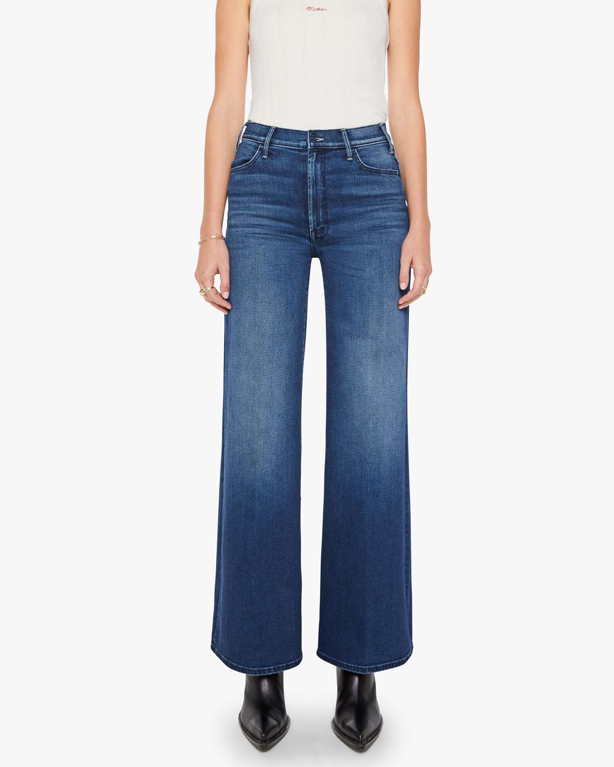Blue stretch denim jeans with black boots, Mother brand, The Hustler Roller Sneak style, shown from shoulders down.