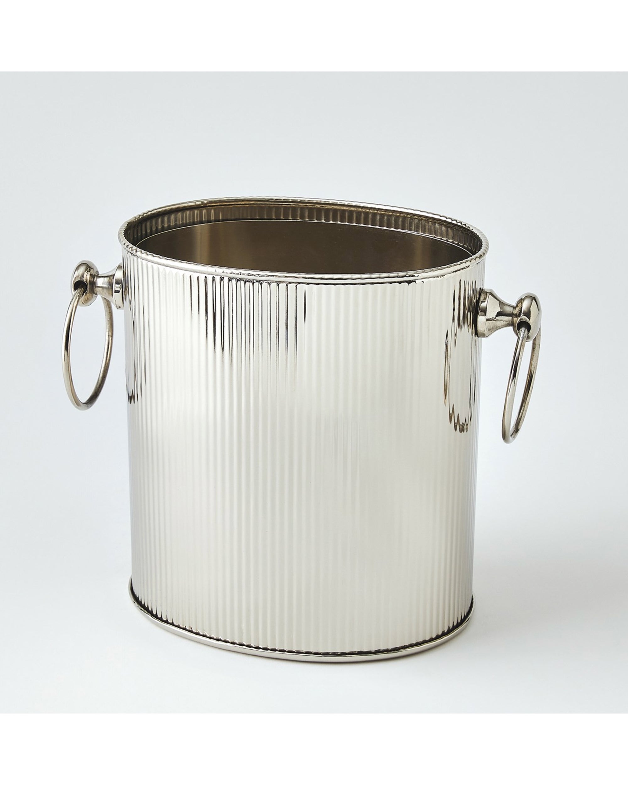 The Global Views 9.94072 Winston Ice Bucket L is a shiny stainless steel, oval-shaped bucket with a fluted design and large round side handles, displayed against a plain white background.