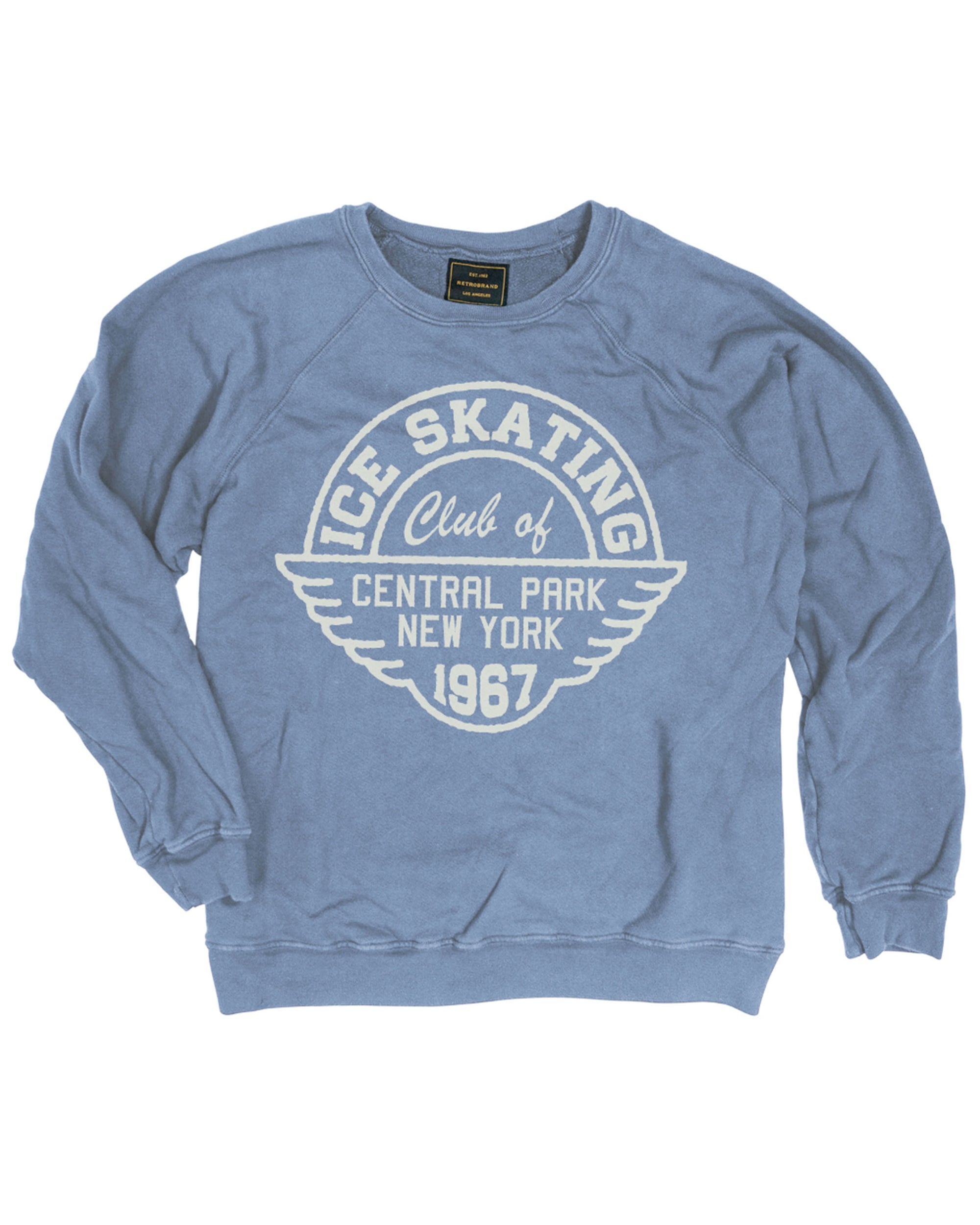 Wildcat Retro Brands' "Ice Skating Central Park" is a vintage-style, USA-made French terry sweatshirt in blue with white "Ice Skating Club of Central Park New York 1967" text and a winged emblem graphic on the front.