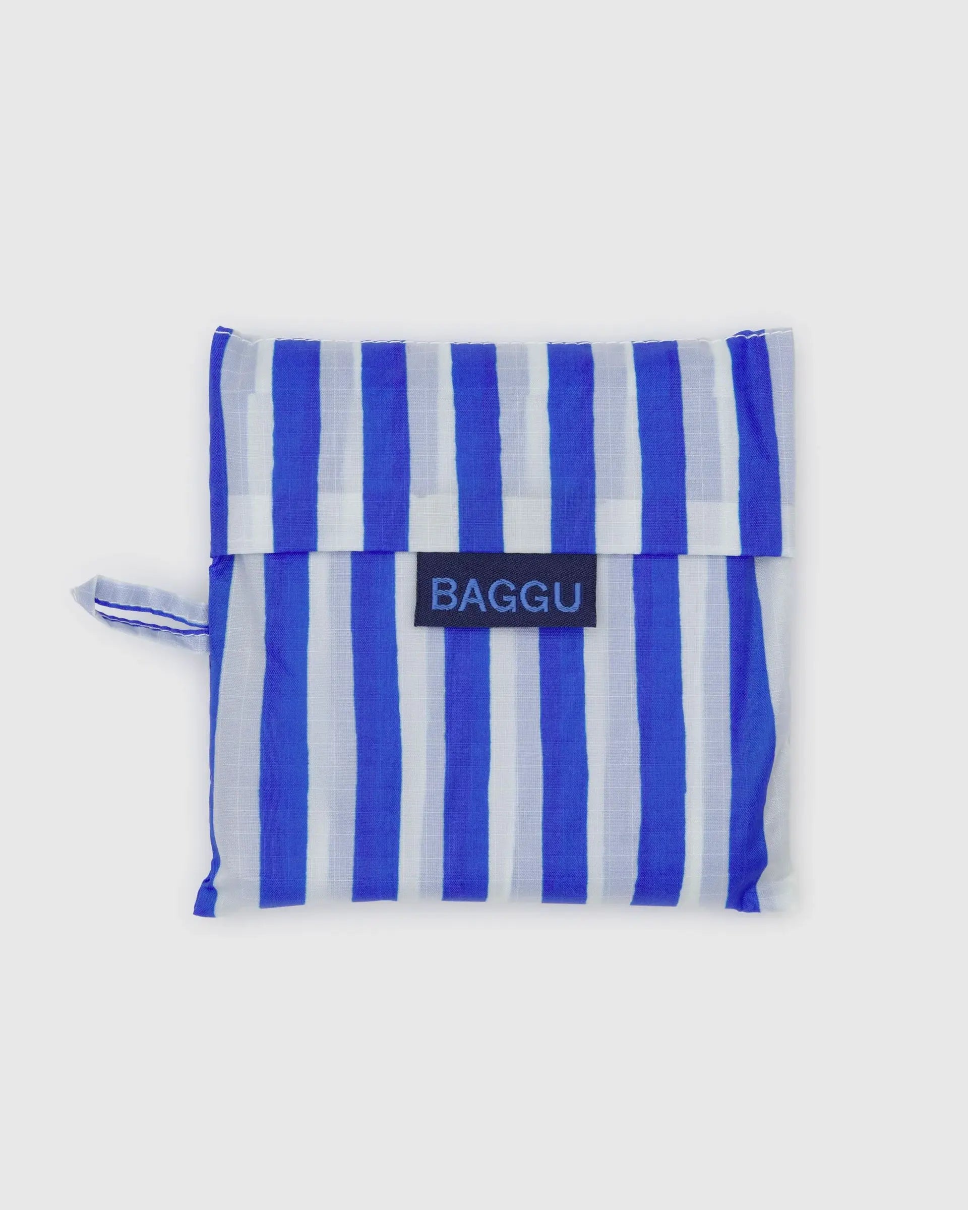 The Baggu Standard by Baggu is a folded, reusable shopping bag made from recycled ripstop nylon in blue and white vertical stripes, shown on a plain white background.
