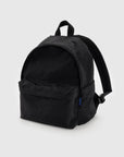 The Baggu Nylon Backpack, crafted from recycled nylon, comes in black with a large main compartment and front pocket. It features adjustable shoulder straps, a small top handle, a laptop sleeve, and its subtle texture with simple design makes it ideal for everyday use.