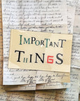 The Faire Important Things Glass Tray features a sign with “Important Things,” where a red number 6 forms the "G," atop handwritten letters. Its varied fonts and colors evoke vintage charm and a handcrafted, découpage-inspired look.