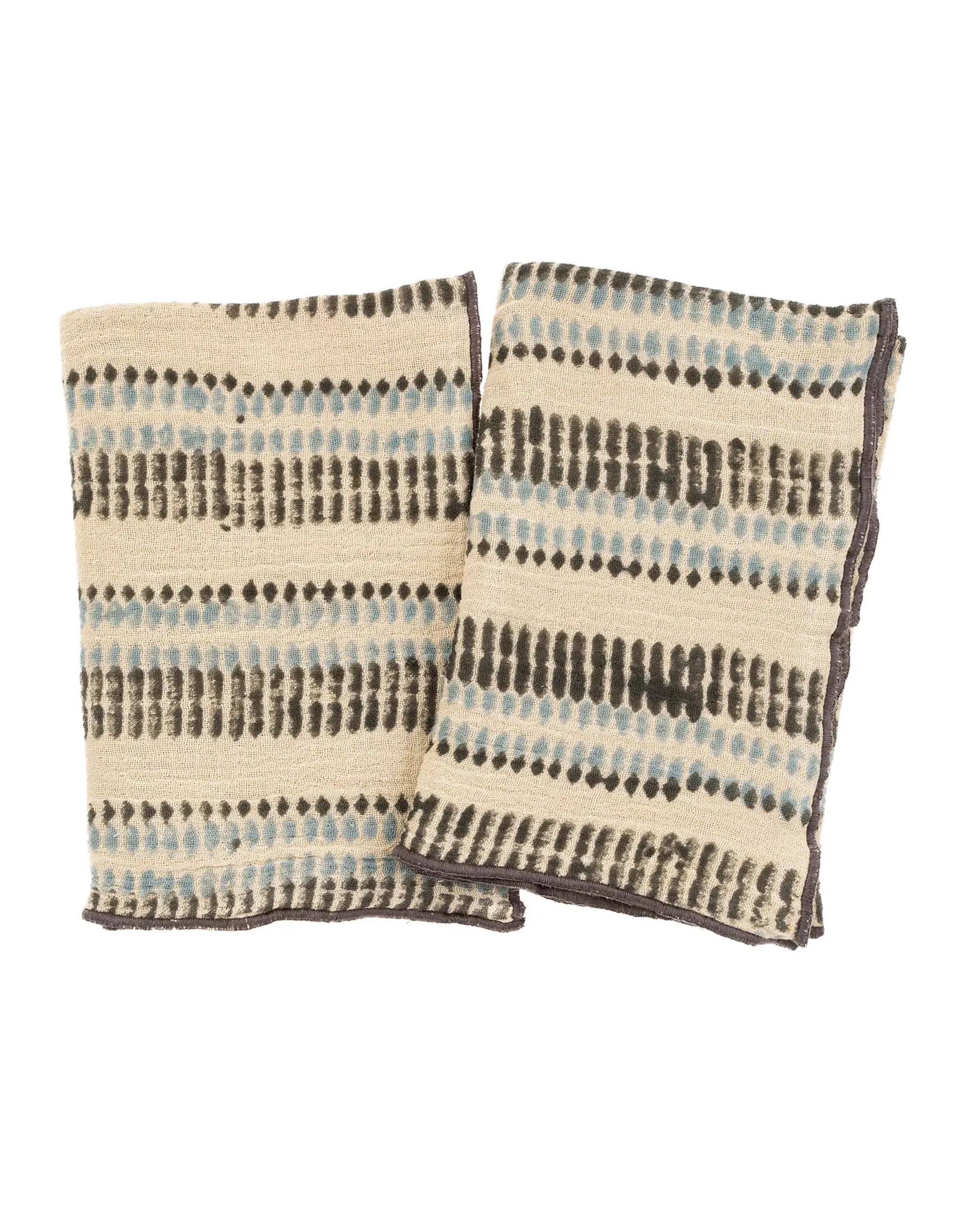 Two folded Ishita Block Print Tea Towels by Indaba, cream-colored with horizontal black and blue dotted stripes, are displayed side by side on a plain white background.