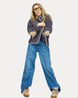 Kerri Rosenthal Coze Magoze anthracite jacket styled with blue jeans and brown sneakers on a white background.